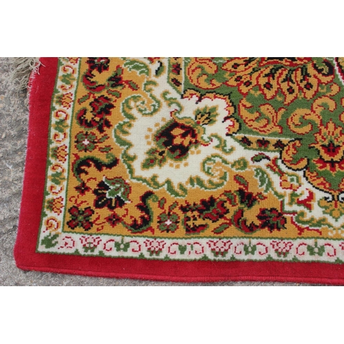 608 - A rug of traditional Continental design on a red ground, 114