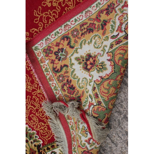 608 - A rug of traditional Continental design on a red ground, 114