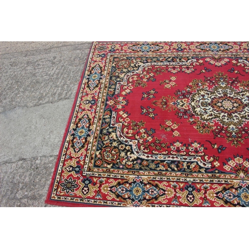 608 - A rug of traditional Continental design on a red ground, 114