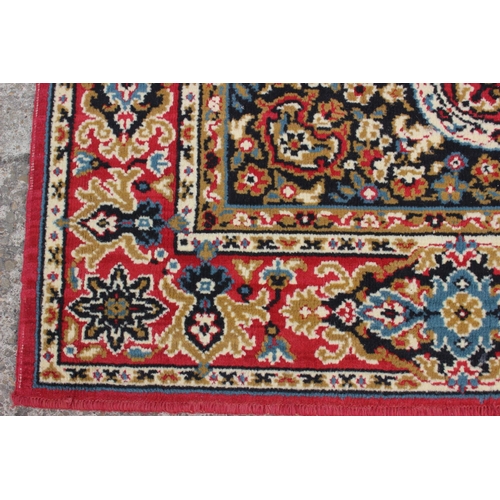 608 - A rug of traditional Continental design on a red ground, 114