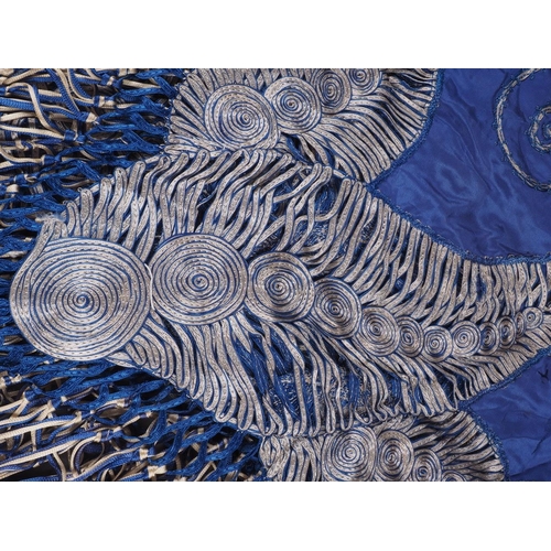 169 - An early 20th century blue silk shawl with ribbon and tassel decoration, 44