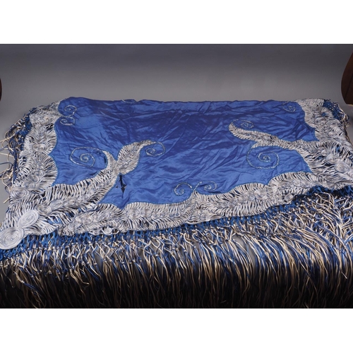 169 - An early 20th century blue silk shawl with ribbon and tassel decoration, 44