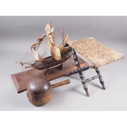 186 - A stonemason's mallet, a Victorian ebonised bobbin turned footstool and a wooden model of a 16th cen... 