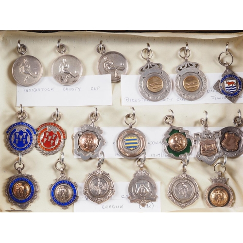 268 - Nineteen early 20th century and later silver sporting medals, including football and cricket, in gla... 