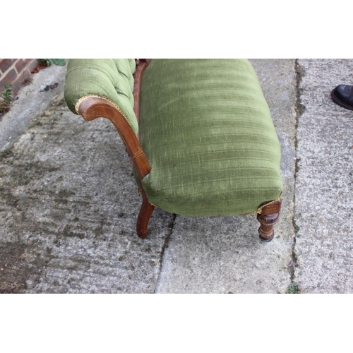 434 - A late 19th century carved walnut showframe two-seat settee, button upholstered in a green velour, o... 