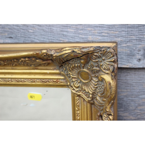 467 - A bevelled edge wall mirror in gilt swept frame, plate 23