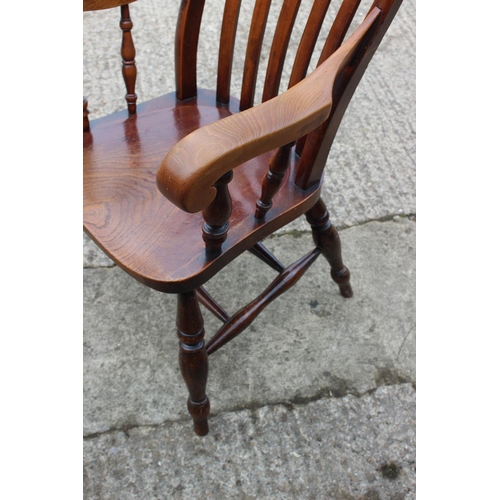 522 - A Windsor lath back elbow chair with panel seat, on turned and stretchered supports