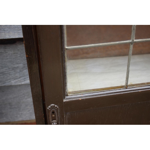 531 - An ebonised bookcase enclosed single leaded glazed door, 21