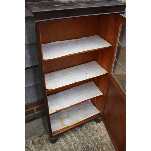 531 - An ebonised bookcase enclosed single leaded glazed door, 21