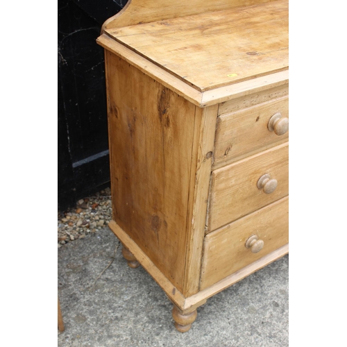 599 - A stripped pine ledge back chest of two short and two long drawers with knob handles, on turned supp... 