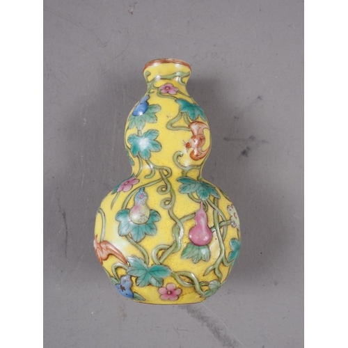 76 - A Chinese double gourd snuff bottle, decorated bats, fruits and flowers, on a yellow ground with sea... 