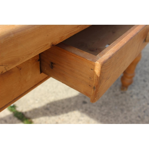 581 - A scrubbed pine kitchen table, fitted one drawer, on turned supports, 54