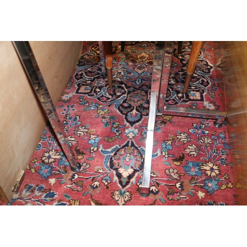 604 - A Persian style carpet of traditional design with central medallion on a red ground in shades of blu... 