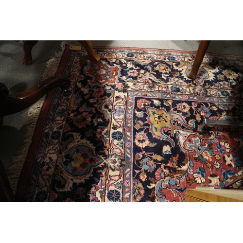 604 - A Persian style carpet of traditional design with central medallion on a red ground in shades of blu... 