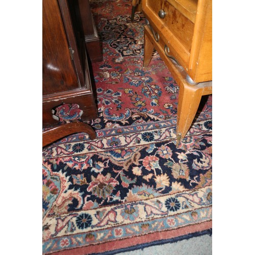 604 - A Persian style carpet of traditional design with central medallion on a red ground in shades of blu... 