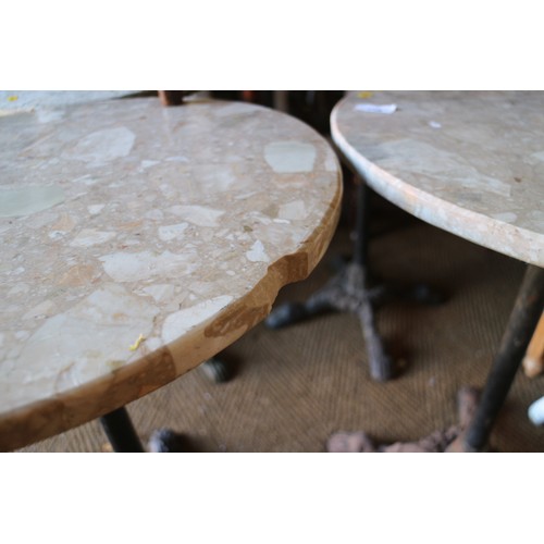 618 - A pair of circular marble topped bistro tables, on cast iron support, 19