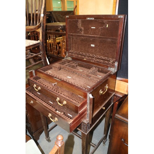 555 - A mahogany canteen with brass side carrying handles, fitted three drawers and side slides, on stand ... 