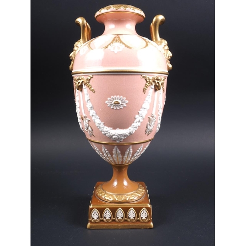 10 - A Wedgwood urn and cover with twin gilt mask handles and relief swag decoration, on a pink ground an... 