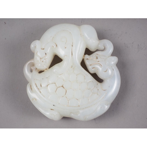 101 - A Chinese pale jade pendant with carved mythical beast decoration, 2