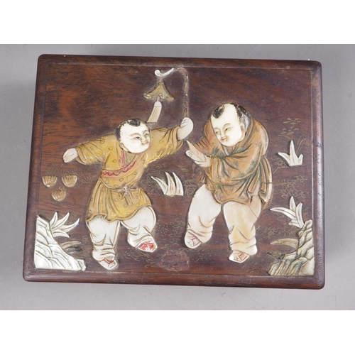 103 - A Japanese hardwood four section box with inset mother-of-pearl and wooden figure decoration. 6 1/2