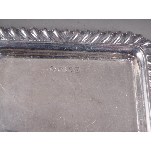 270 - An embossed silver heart-shaped sweetmeat dish, an oval pin tray, a rectangular pin tray, a model sw... 