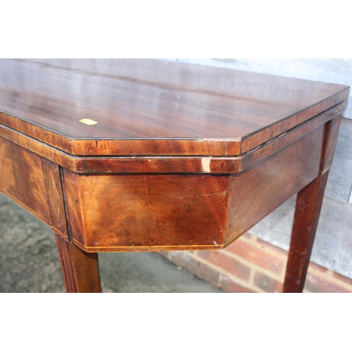 433 - A 19th century mahogany, ebony strung and satinwood banded fold-over top tea table, on reeded taperi... 