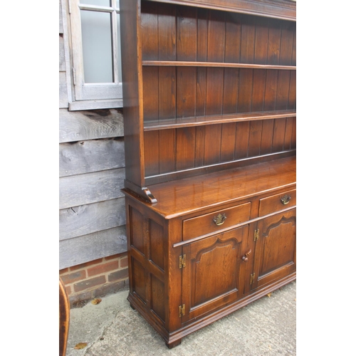 543 - An oak dresser with plate shelves over three drawers and three cupboards enclosed ogee panelled door... 