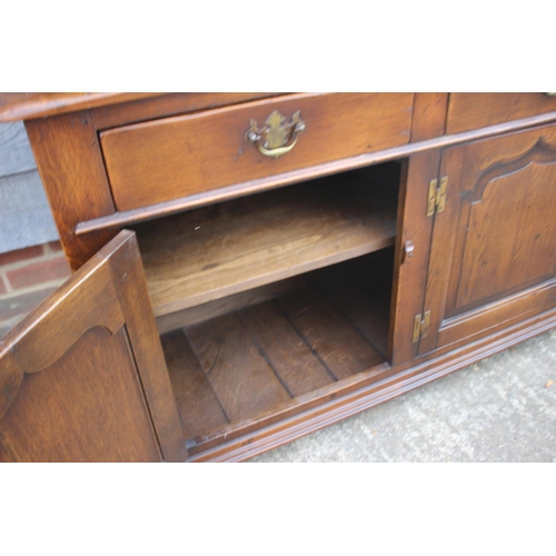 543 - An oak dresser with plate shelves over three drawers and three cupboards enclosed ogee panelled door... 