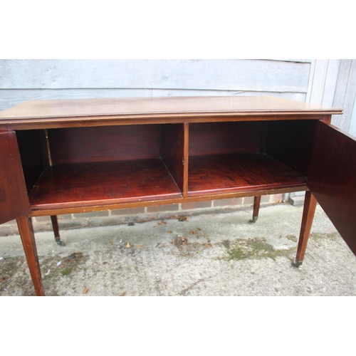 545 - An Edwardian mahogany and banded side cupboard/carving table enclosed two doors, on square taper cas... 