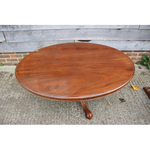 548 - An early 20th century mahogany oval low occasional table, on carved scroll supports, top 54