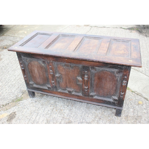 557 - An oak panel front coffer of 17th century design with split turnings, on stile supports, 48