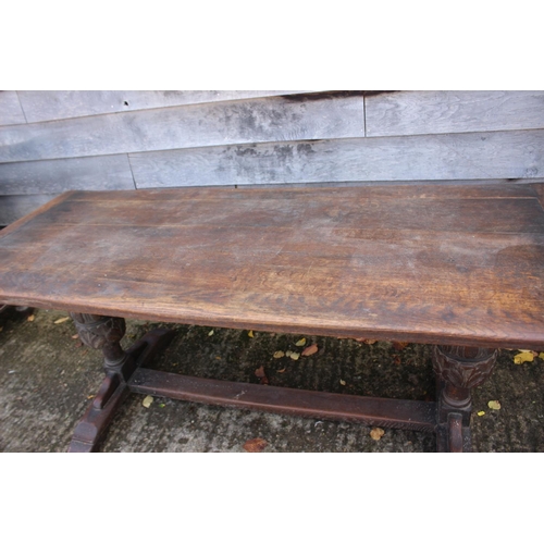 560 - An oak refectory table of 17th century design with cleated planked top, on carved cup and cover supp... 