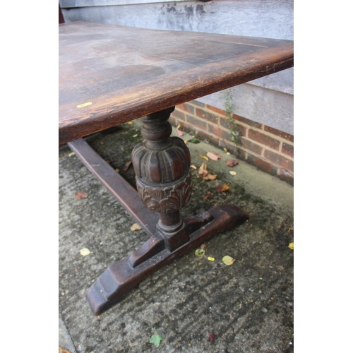 560 - An oak refectory table of 17th century design with cleated planked top, on carved cup and cover supp... 