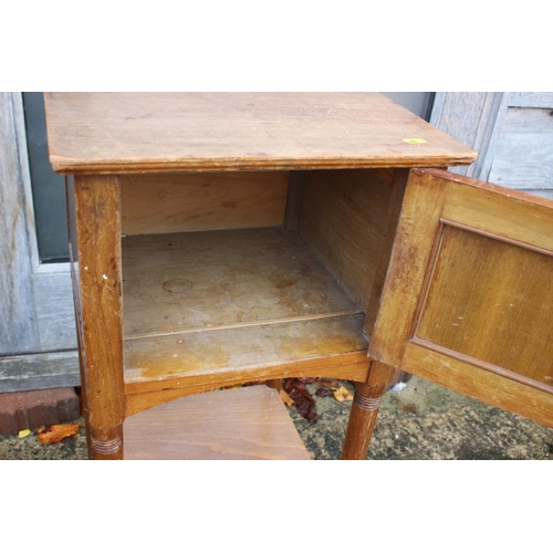 561 - An early 20th century walnut bedside cupboard enclosed one door over undertier, on turned supports, ... 