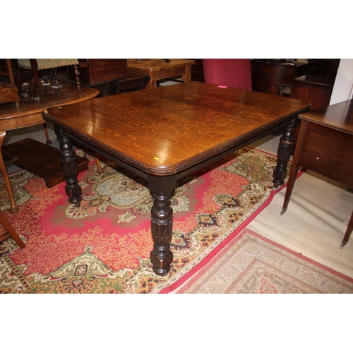 563 - An Edwardian oak extending dining table with four extra leaves, on bulbous turned and carved support... 