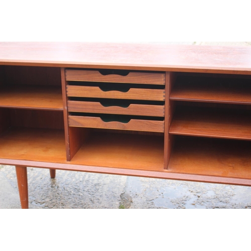 574 - A 1960s teak sideboard, the interior fitted drawers and shelves enclosed two tambour shutter doors, ... 