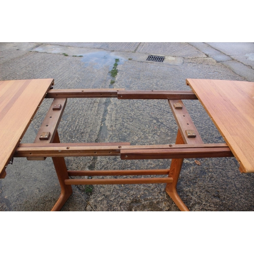 576 - A 1960s teak extending dining table with two extra leaf, on splay supports, 88