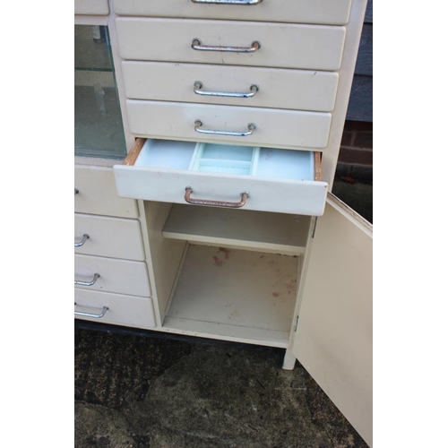 580 - A dentist's instrument cabinet with black glass top, fitted fifteen drawers, central glazed cupboard... 