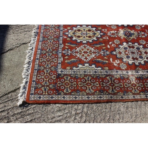 582 - A Hamadan type rug with numerous shaped medallions and on a rust ground and multi-bordered in blue, ... 