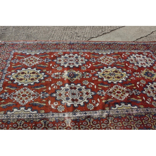 582 - A Hamadan type rug with numerous shaped medallions and on a rust ground and multi-bordered in blue, ... 