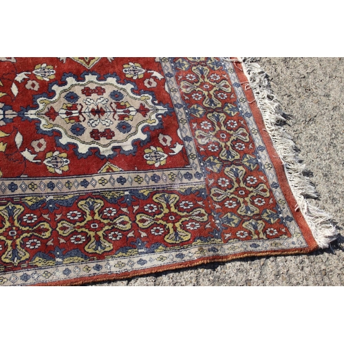 582 - A Hamadan type rug with numerous shaped medallions and on a rust ground and multi-bordered in blue, ... 