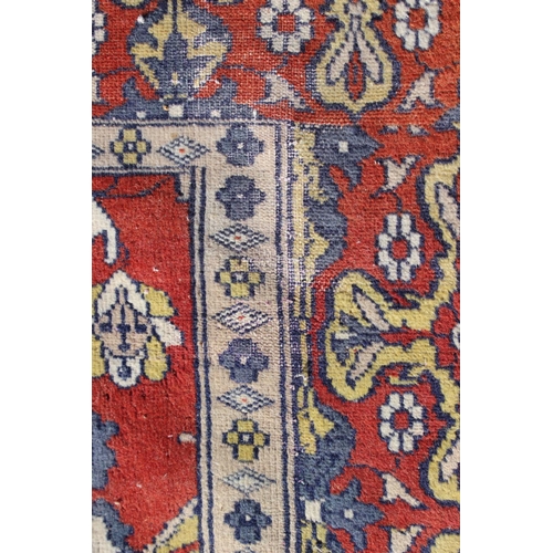 582 - A Hamadan type rug with numerous shaped medallions and on a rust ground and multi-bordered in blue, ... 