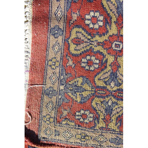 582 - A Hamadan type rug with numerous shaped medallions and on a rust ground and multi-bordered in blue, ... 