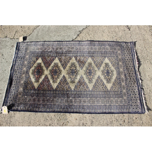 590 - A Bokhara rug of traditional design, in shades of faun, blue, brown and natural, 30