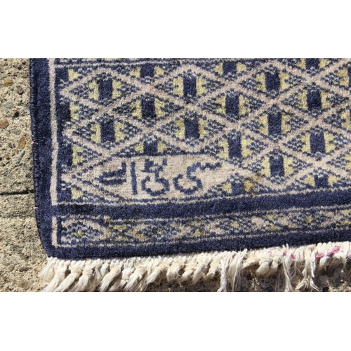 590 - A Bokhara rug of traditional design, in shades of faun, blue, brown and natural, 30