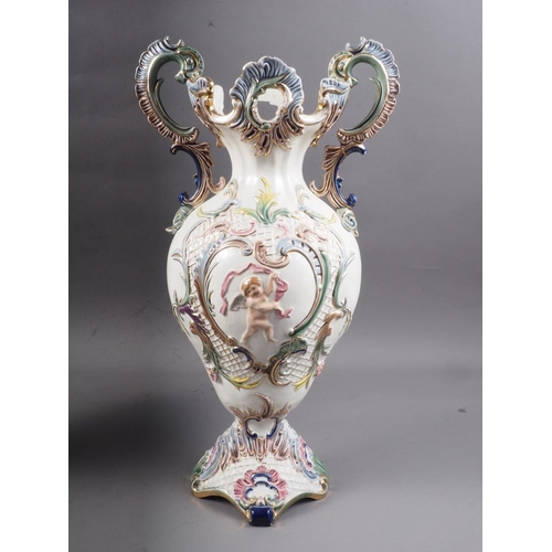 62 - A pair of antique style Continental two-handled vases, decorated relief cherubs and scrolls, 15 1/4