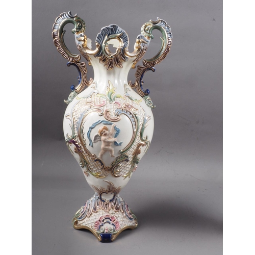 62 - A pair of antique style Continental two-handled vases, decorated relief cherubs and scrolls, 15 1/4