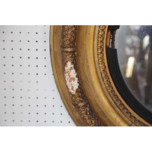 495 - An early 19th century convex wall mirror, in ebonised reeded and gilt frame, plate 15