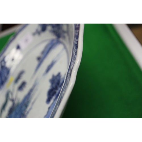 94 - A Chinese blue and white shaped edge dish with landscape decoration and floral borders, 13