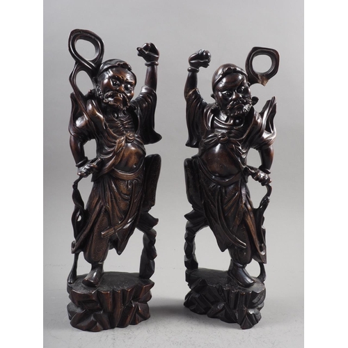 123 - A pair of Oriental hardwood carvings of Immortals, inlaid silver wire, 16